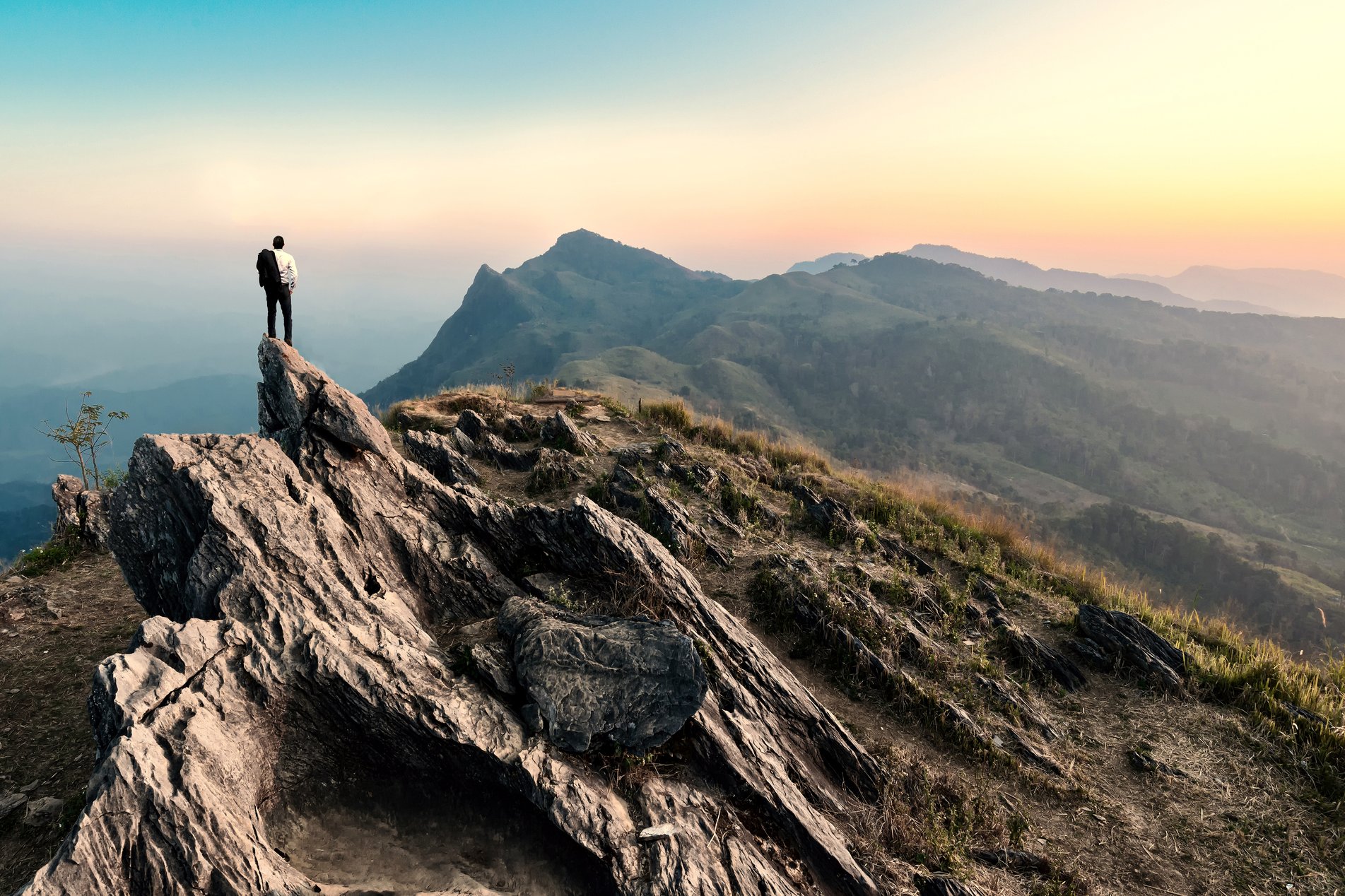 Businessman hiking on peak of mountain at sunset_XXL.jpg